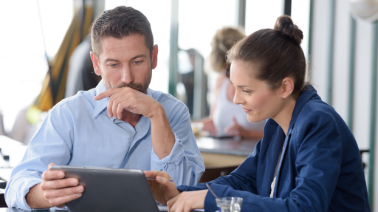 Two engineers reviewing PiControl software on a tablet